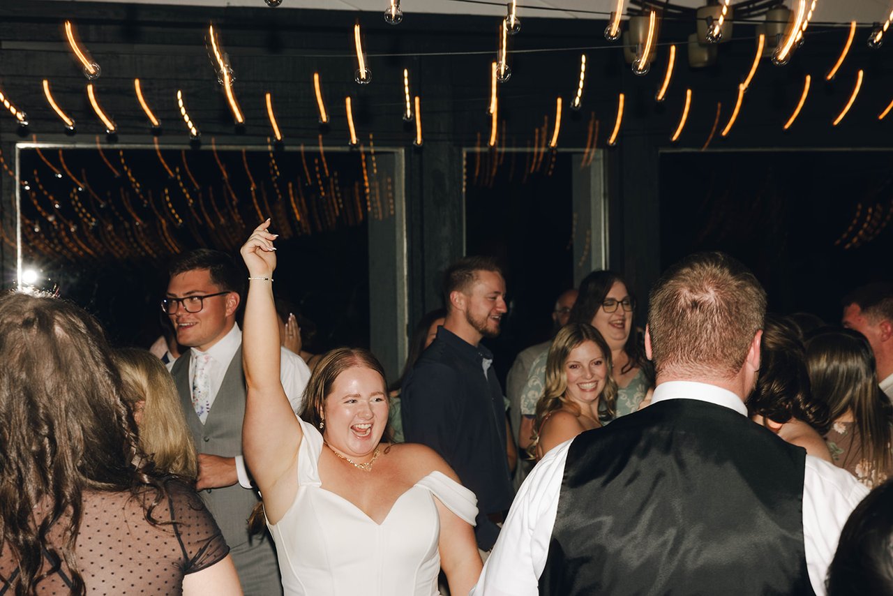 Autumn laughs with one arm up on a packed dance floor