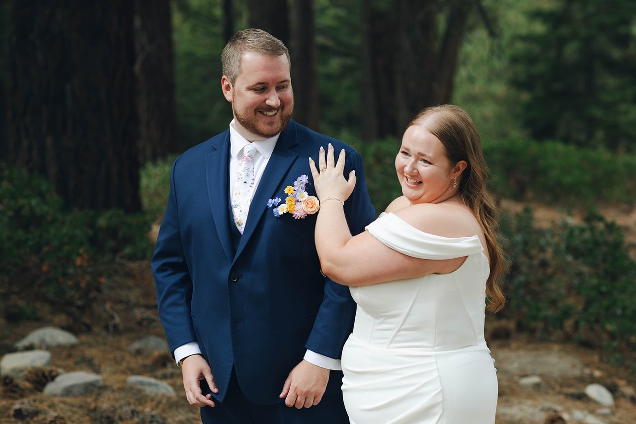 Autumn and Peter laugh together among the pines, her hand on his chest
