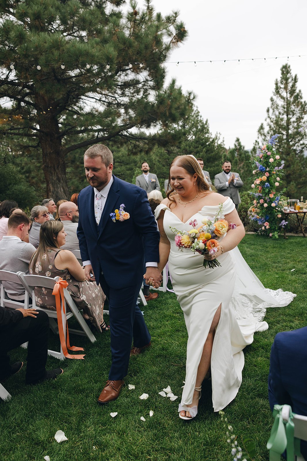 Autumn and Peter walk back up the aisle hand in hand, Autumn laughing