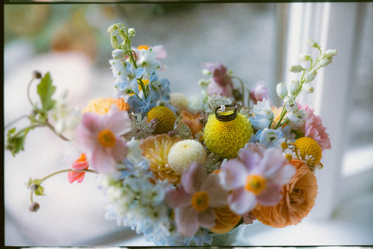 The wedding rings resting on the flowers of the bridal bouquet