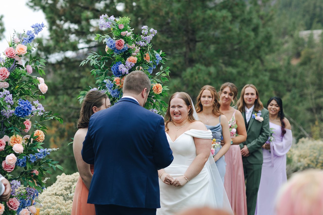 Autumn laughs during the vows with her bridesmaids smiling behind her