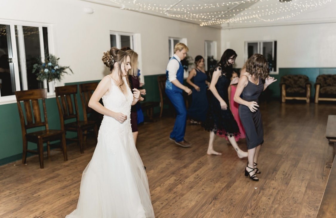 Caitlyn dances with her guests on the wood floor of the hall