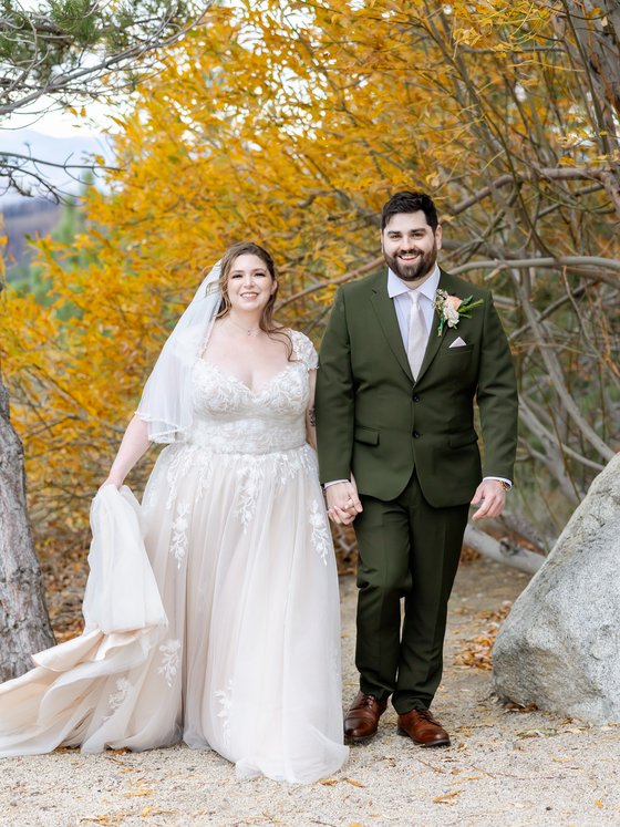 Danielle and Brandon walk hand in hand under the golden aspens at Tannenbaum