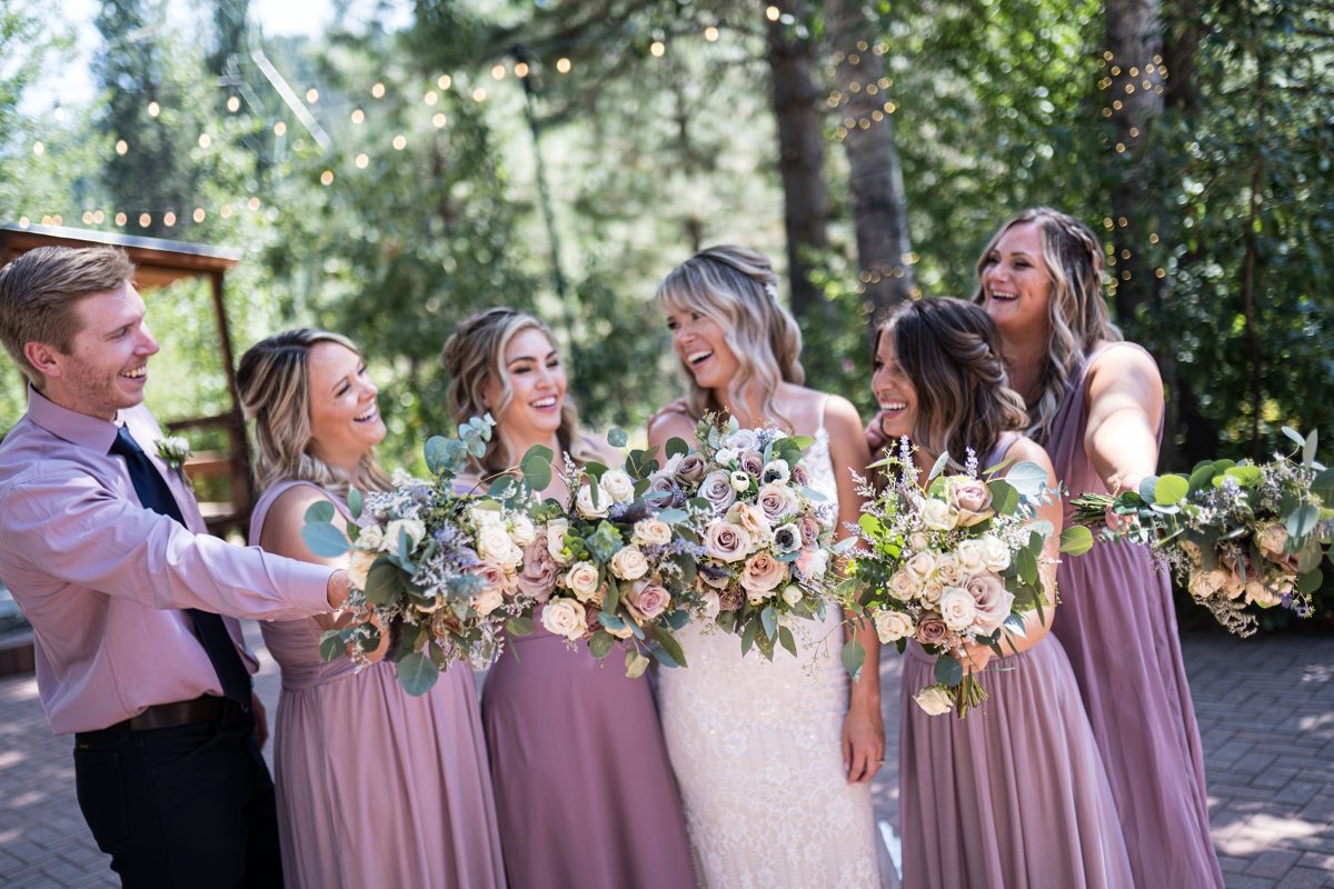 The wedding party shares a laugh among the pines at Twenty Mile House