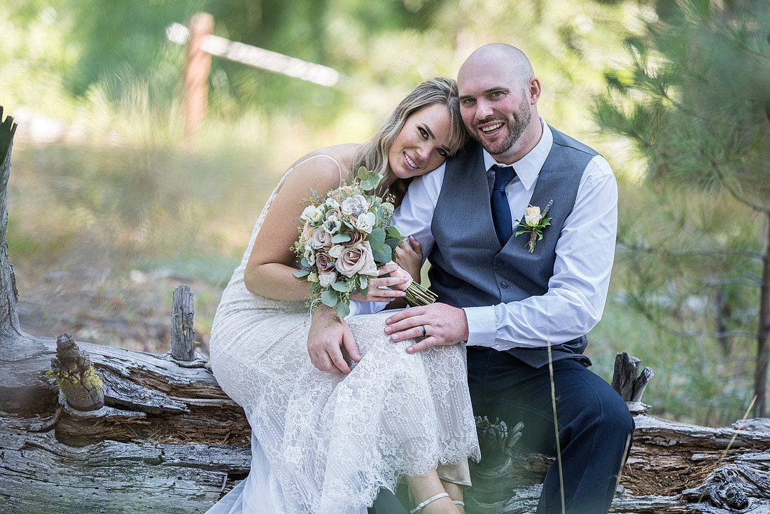 Correen and Kellen cuddle on the log by the meadow