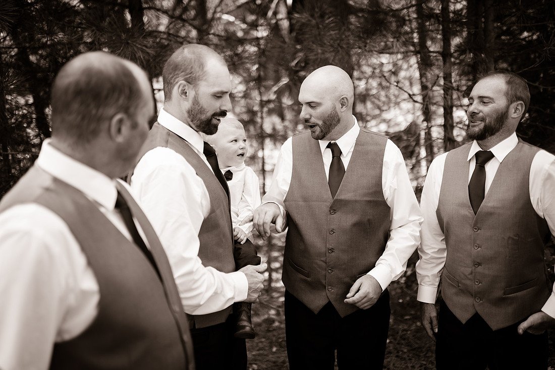 A sepia photo of Kellen sharing a laugh with his groomsmen