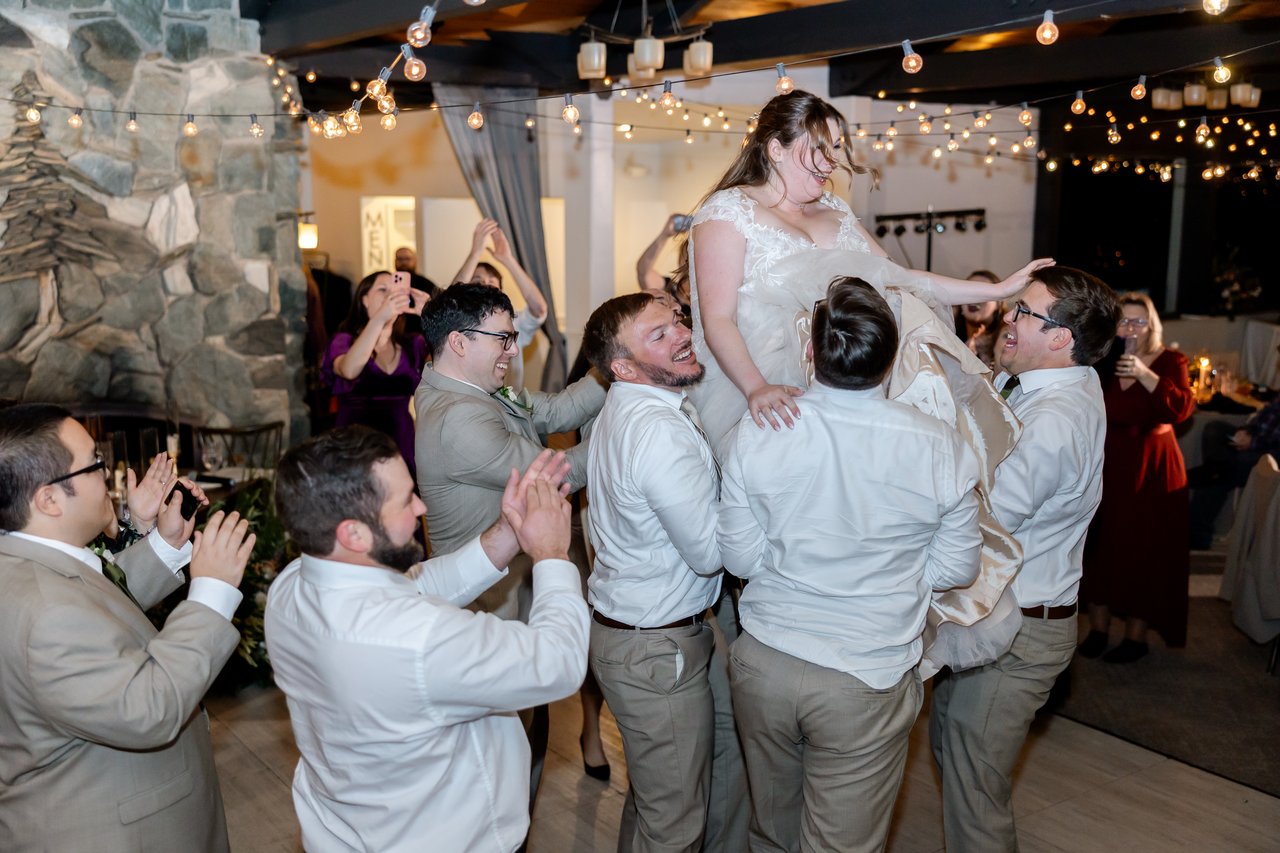 Danielle rides high in a chair above the groomsmen