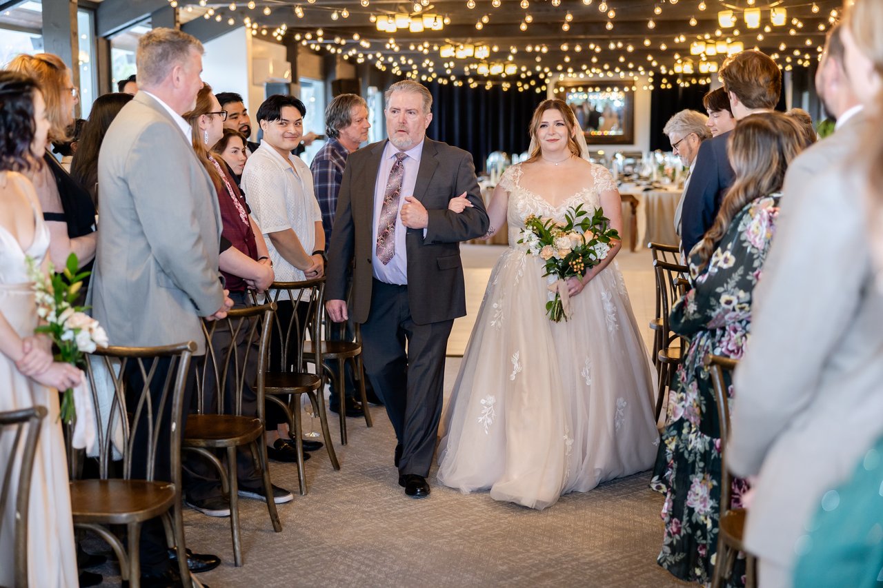 Danielle walks down the aisle with her dad as guests stand
