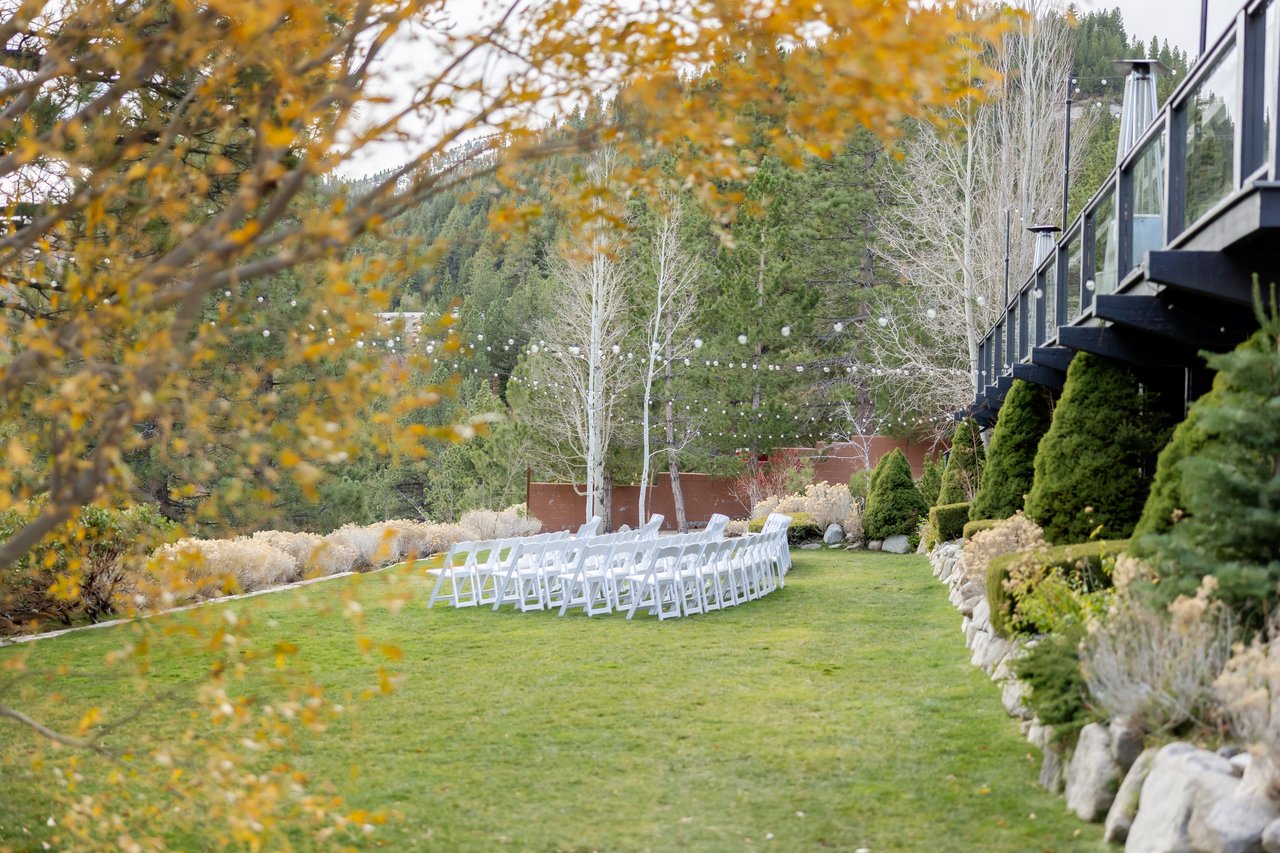 White ceremony chairs on the lawn framed by golden aspens at the Tannenbaum