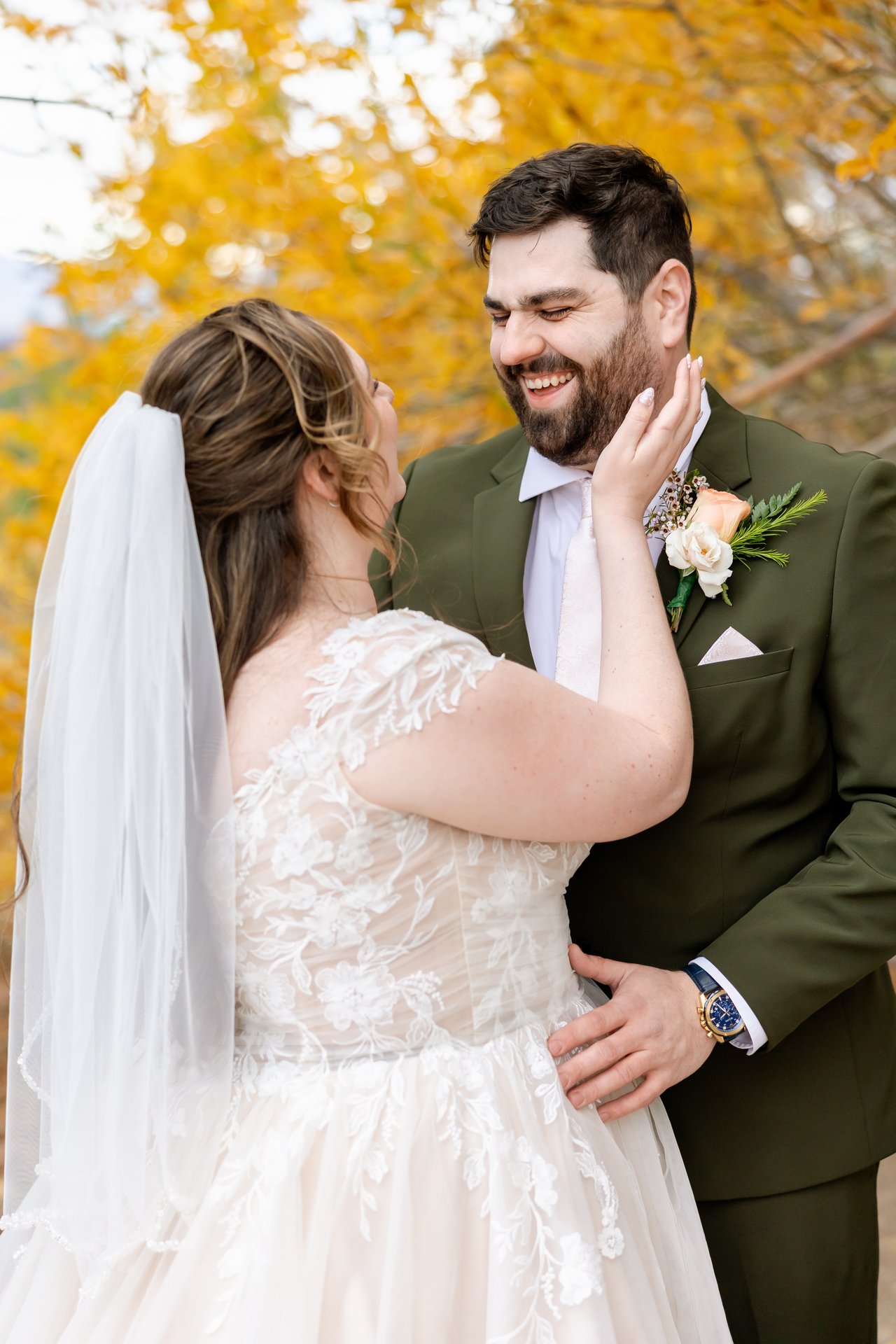 Brandon laughs as Danielle holds his cheek under the golden aspens
