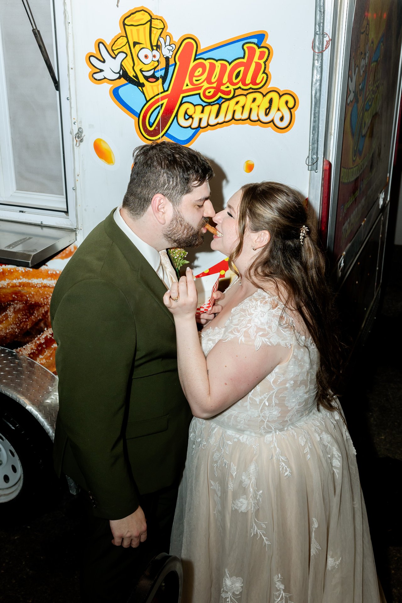 Danielle and Brandon kiss in front of the churro truck