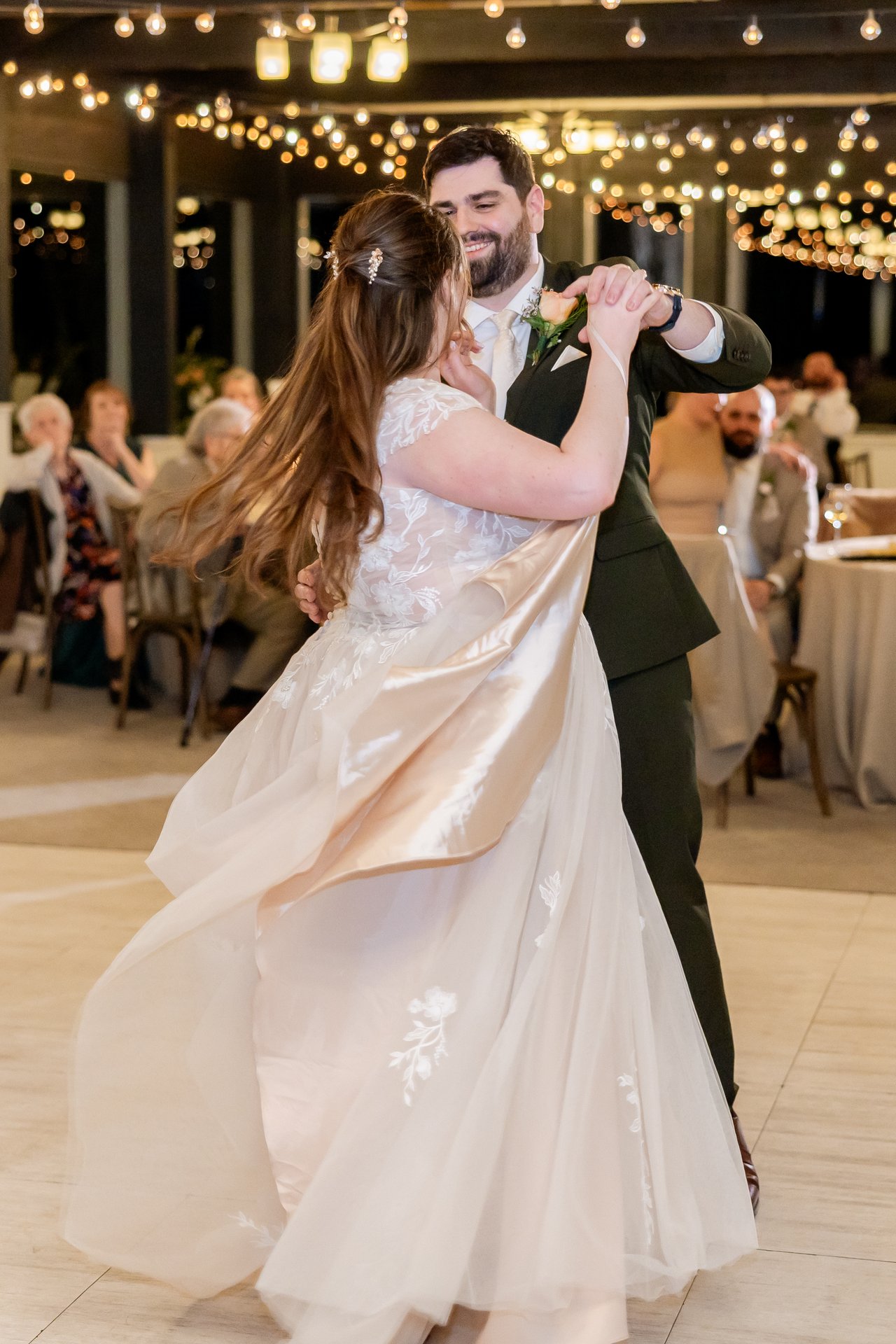 Danielle and Brandon spin through their first dance under the string lights
