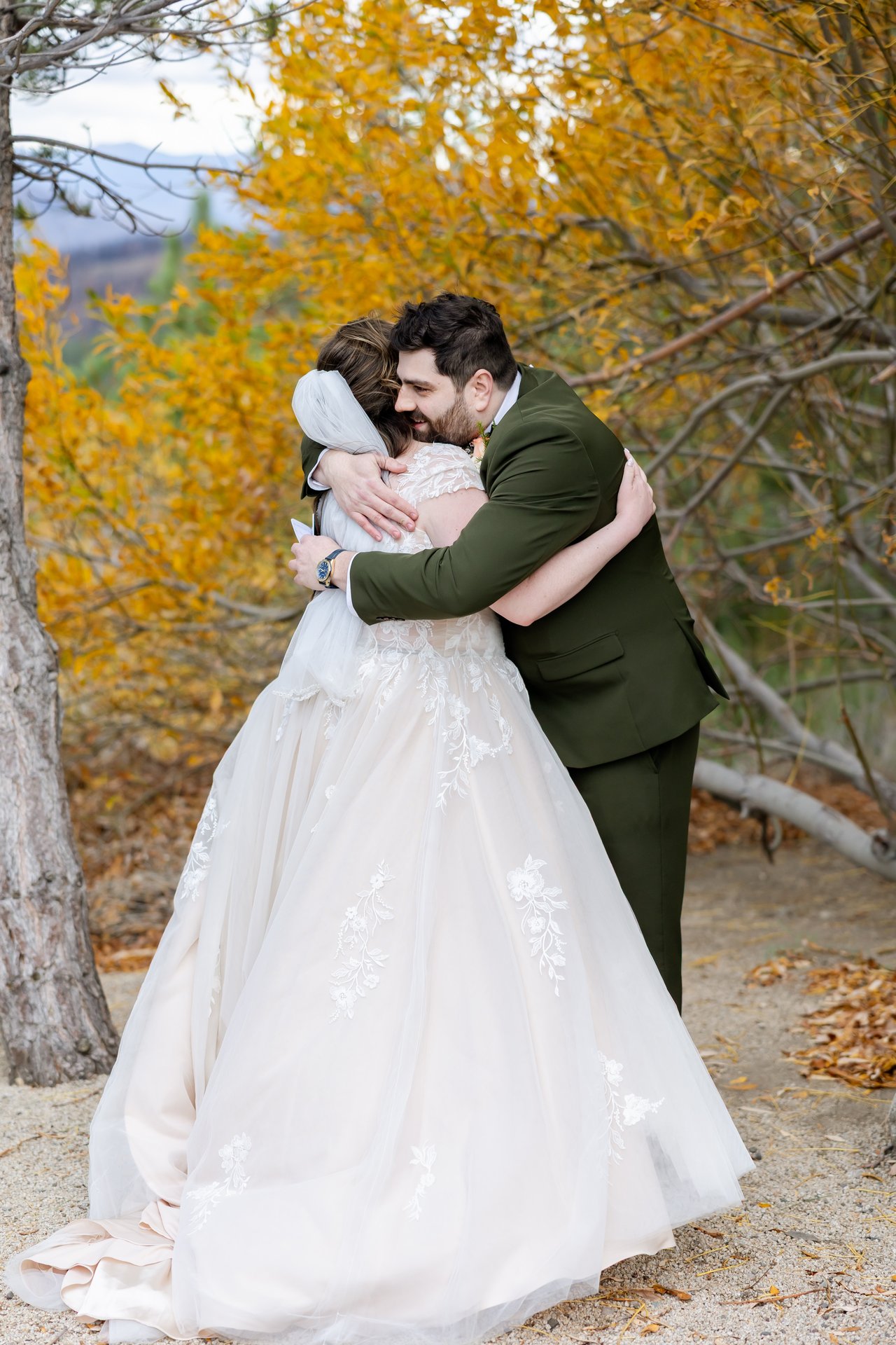 Danielle and Brandon hug at their first look among the yellow aspens