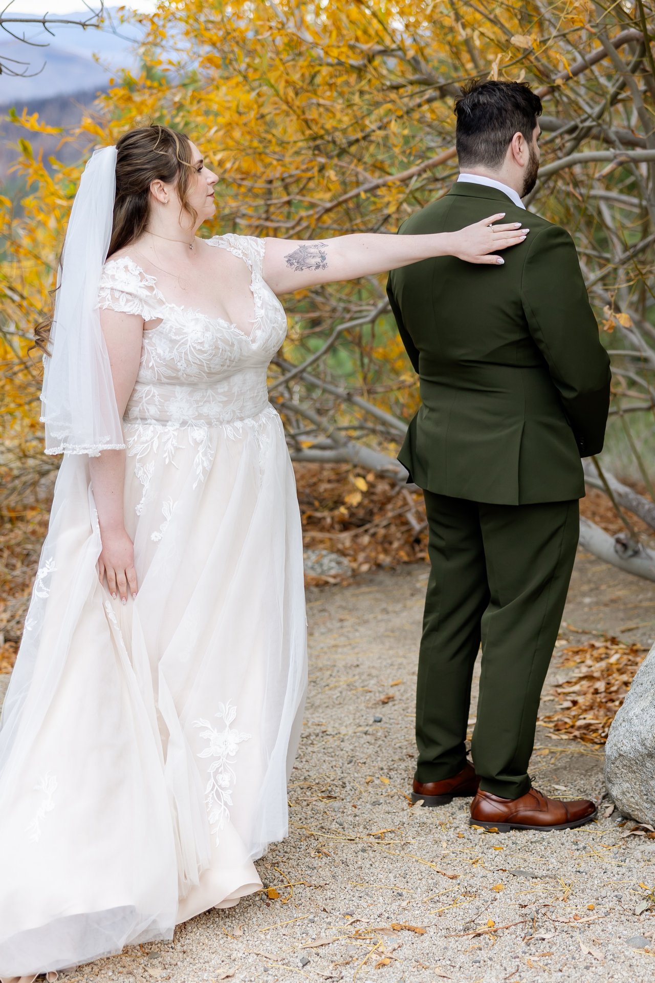 Danielle reaches out to tap Brandon's shoulder for their first look under golden aspens