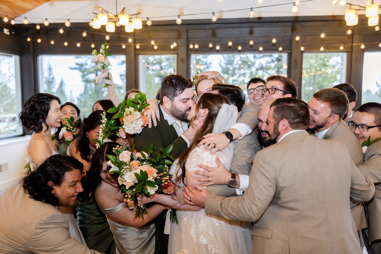 The wedding party wraps Danielle and Brandon in a group hug