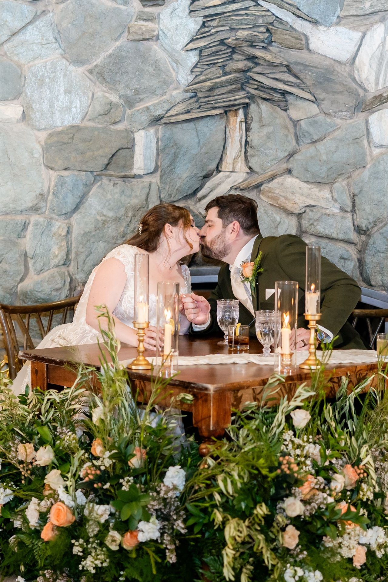Danielle and Brandon kiss at the sweetheart table after a toast