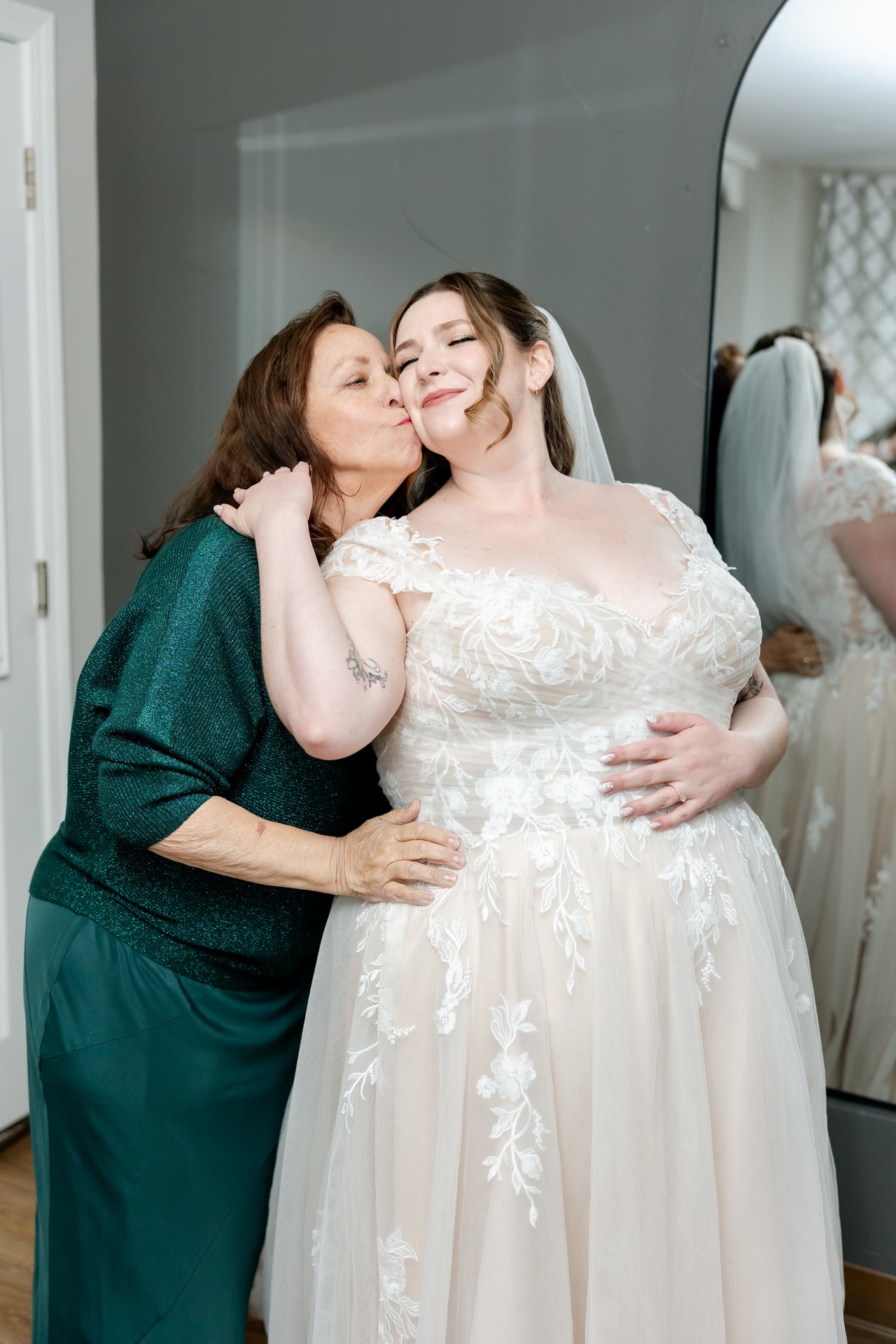 A woman in green kisses Danielle on the cheek after she gets into her gown