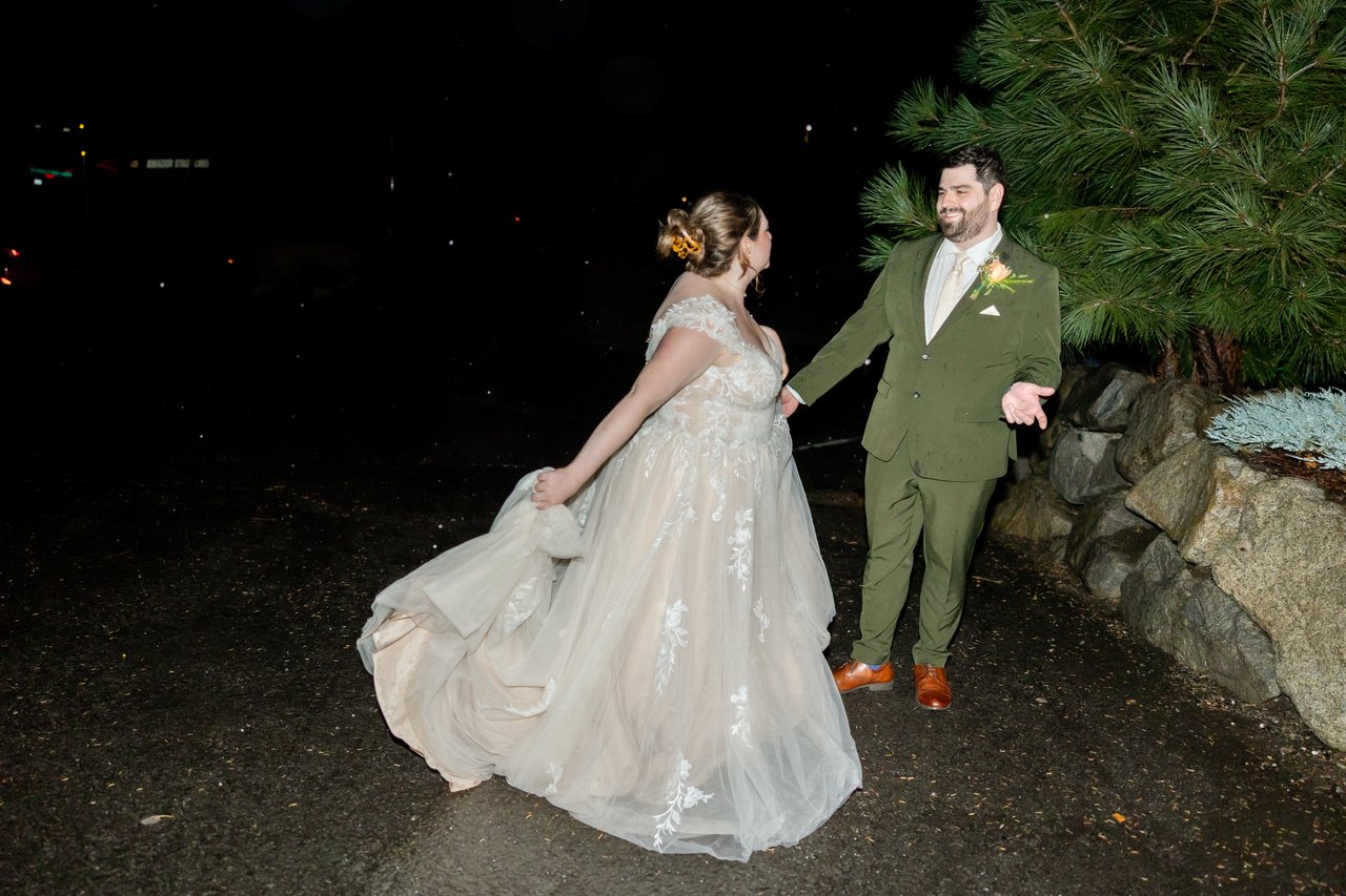 Danielle twirls her gown outside at night as Brandon holds her hand
