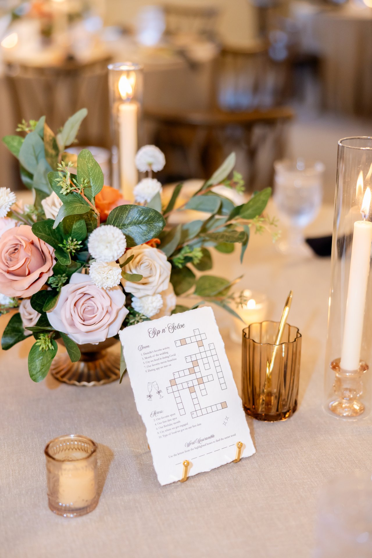 A centerpiece of peach roses, greenery and candles