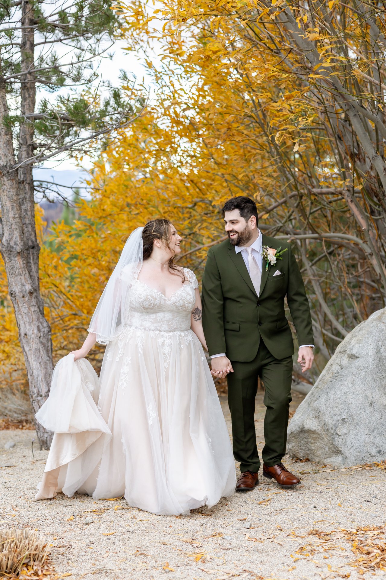 Danielle and Brandon walk hand in hand through the aspens