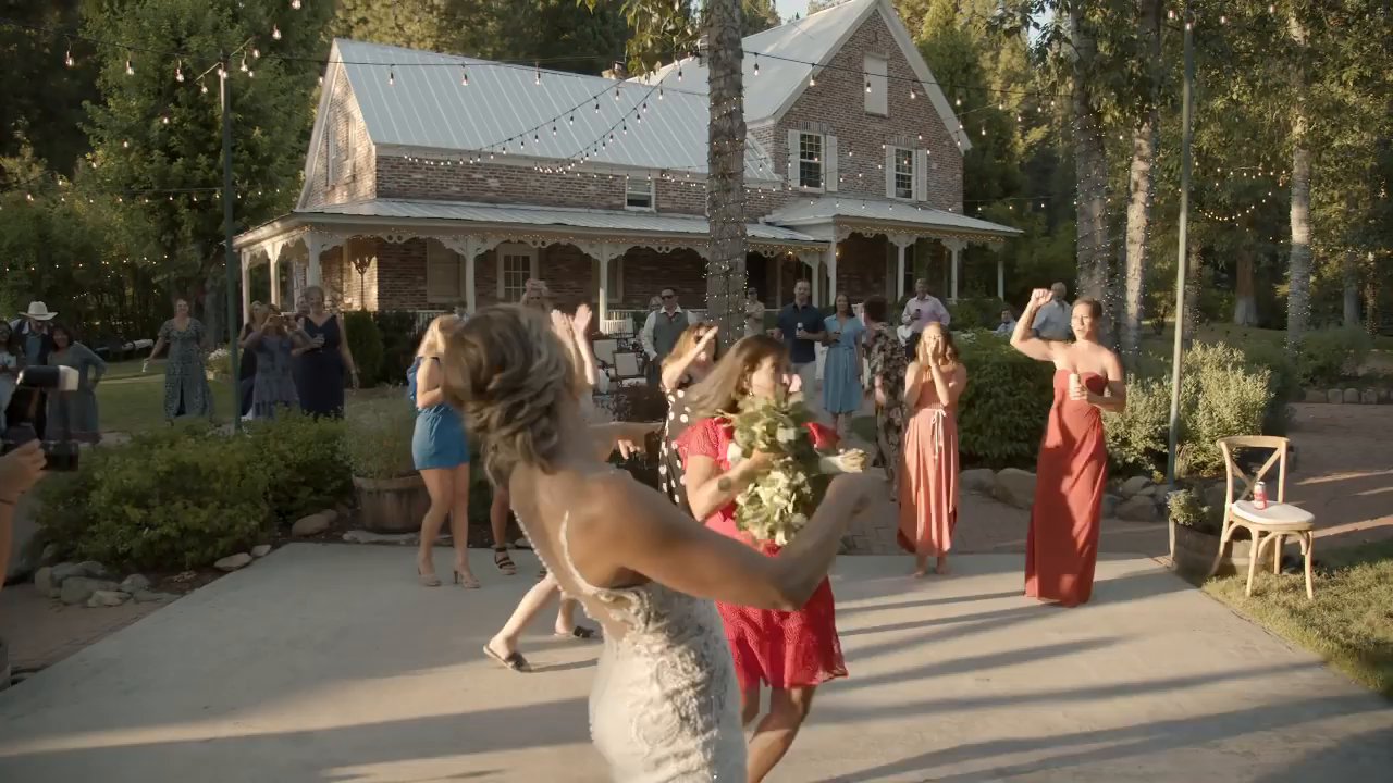 Danielle tosses her bouquet to the guests on the patio.