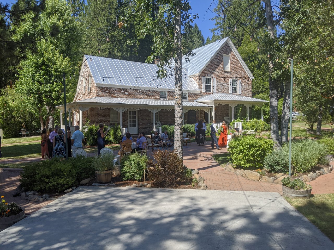 Guests gather in the sun outside the brick house at Twenty Mile House during cocktail hour