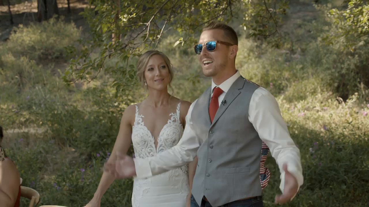 Danielle and Scott smile at the reception, Scott in his sunglasses.