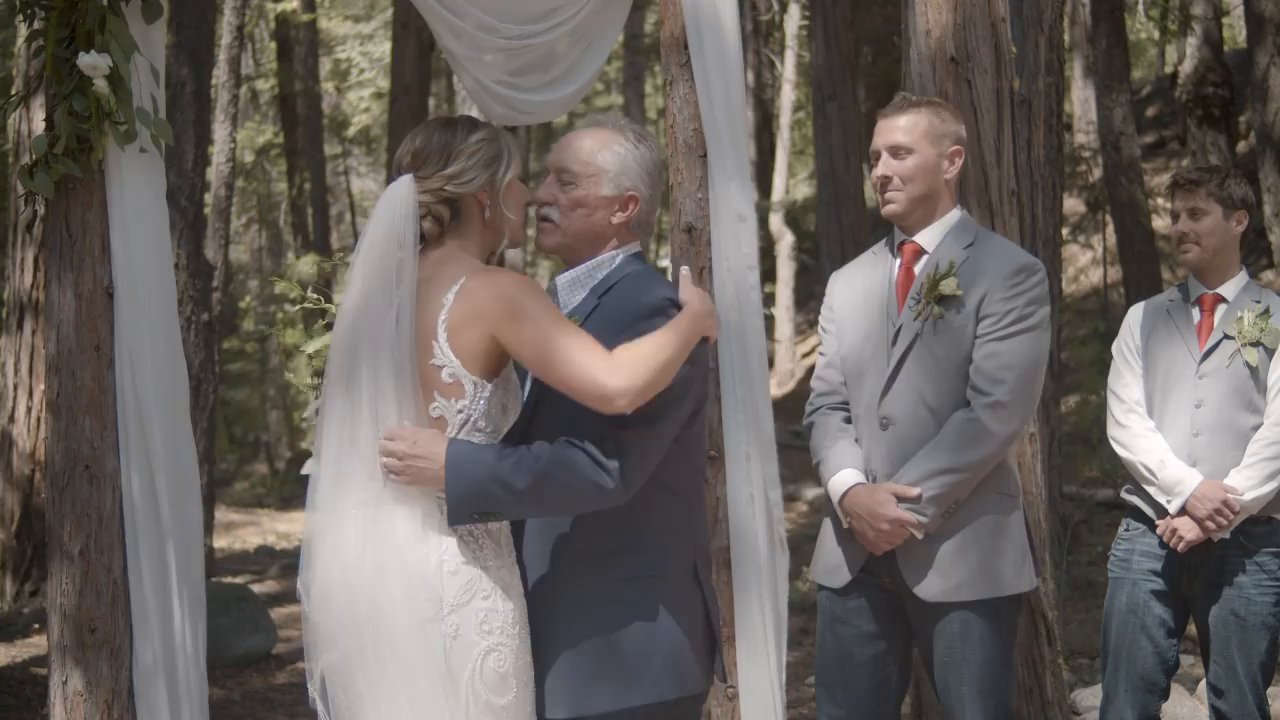 Danielle hugs her dad at the arch as Scott waits beside them.