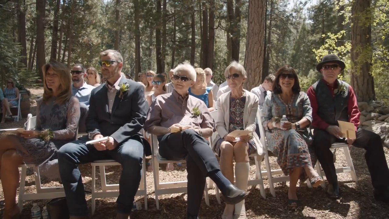 Family in the front row watch the vows with big smiles.