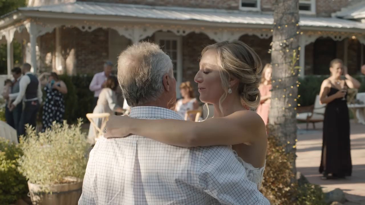 Danielle and her dad hug during their dance as guests look on.