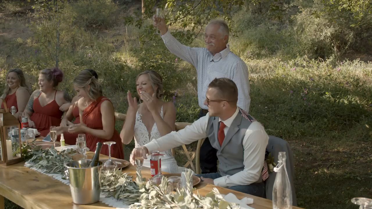 Danielle's dad raises his glass high during his toast at the head table.