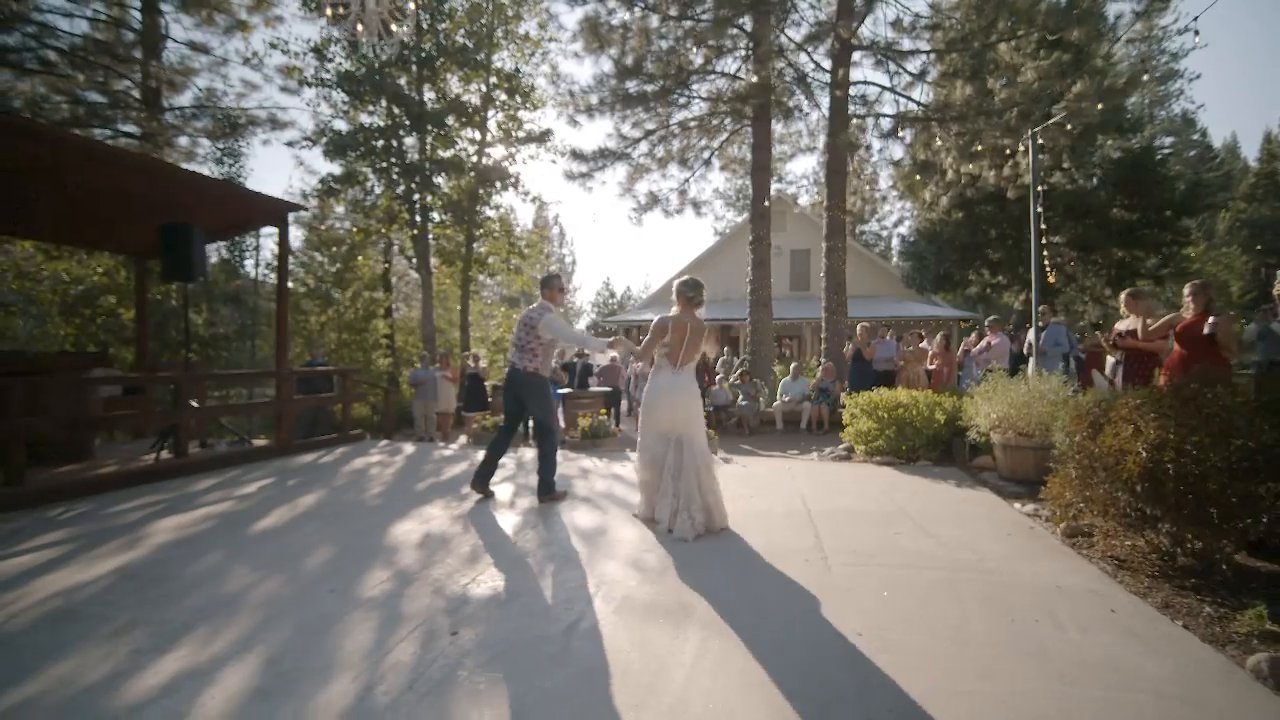 Danielle and Scott share their first dance on the patio, guests circled around.