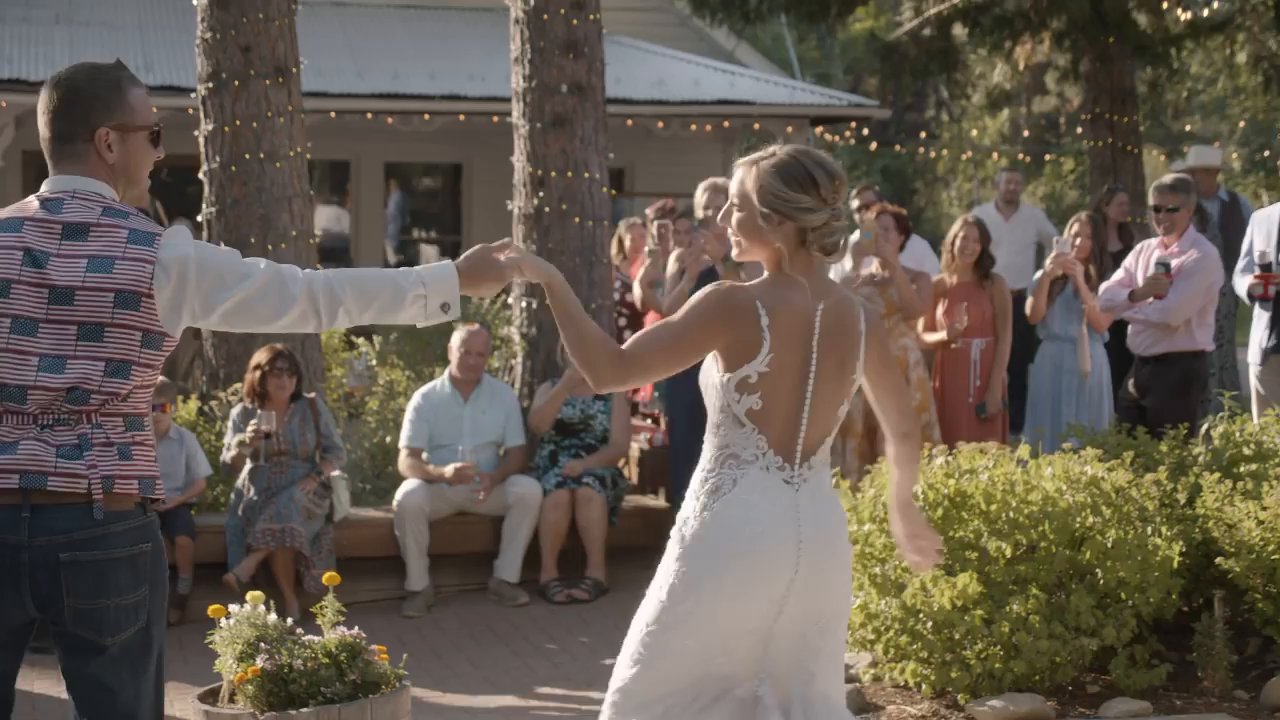 Scott twirls Danielle during their first dance as guests film and cheer.