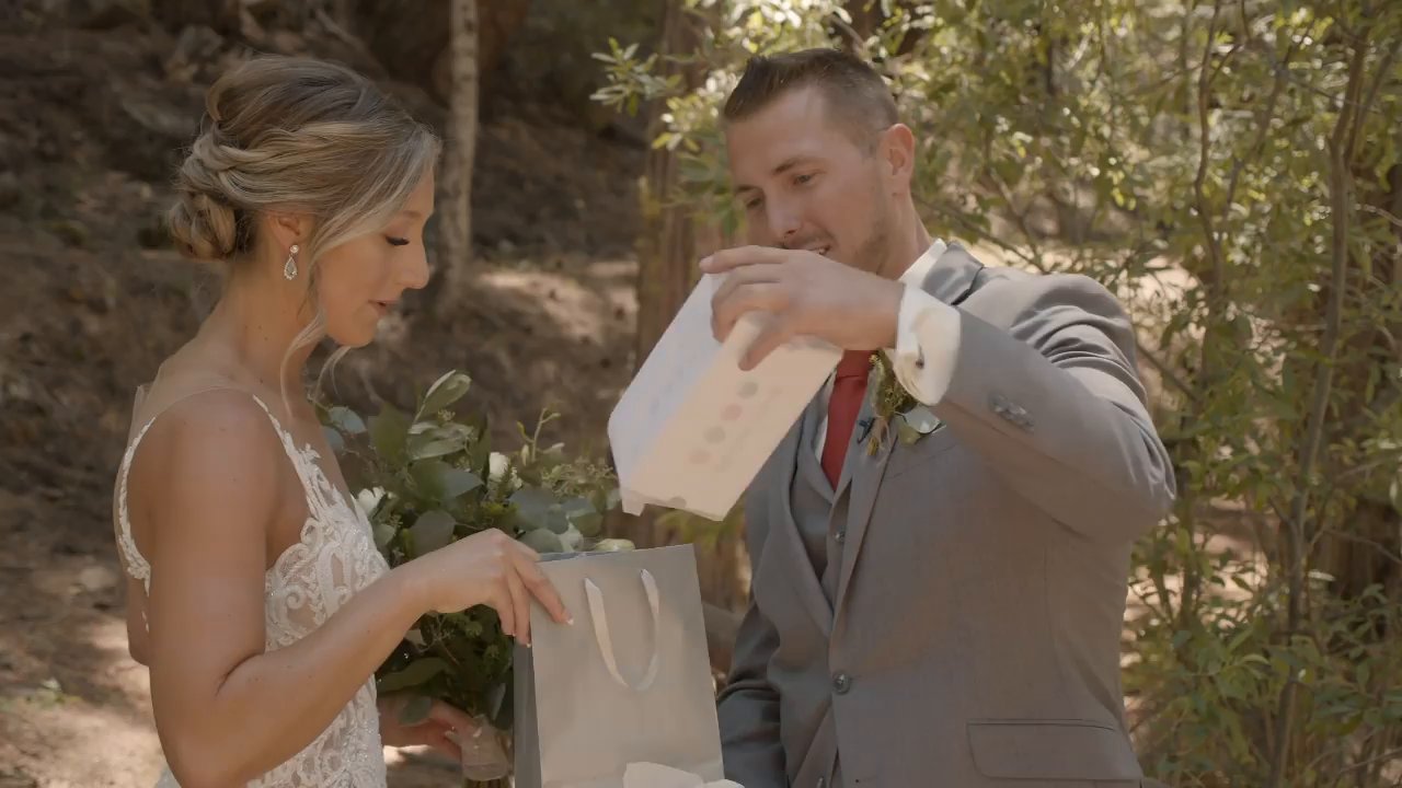 Scott opens a gift bag from Danielle in the forest.