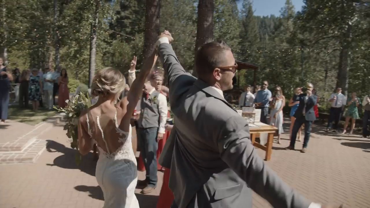 Danielle and Scott make their grand entrance as guests cheer on the patio.