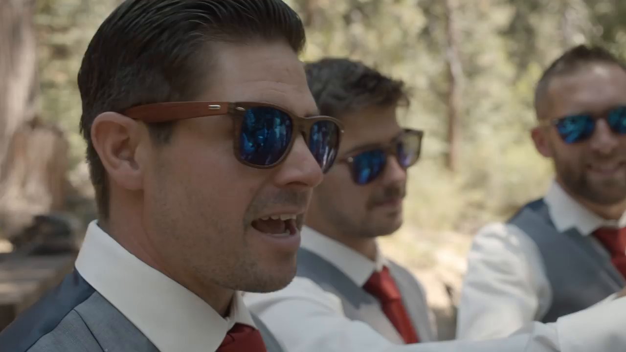 Scott and his groomsmen in sunglasses and red ties, laughing before the ceremony.