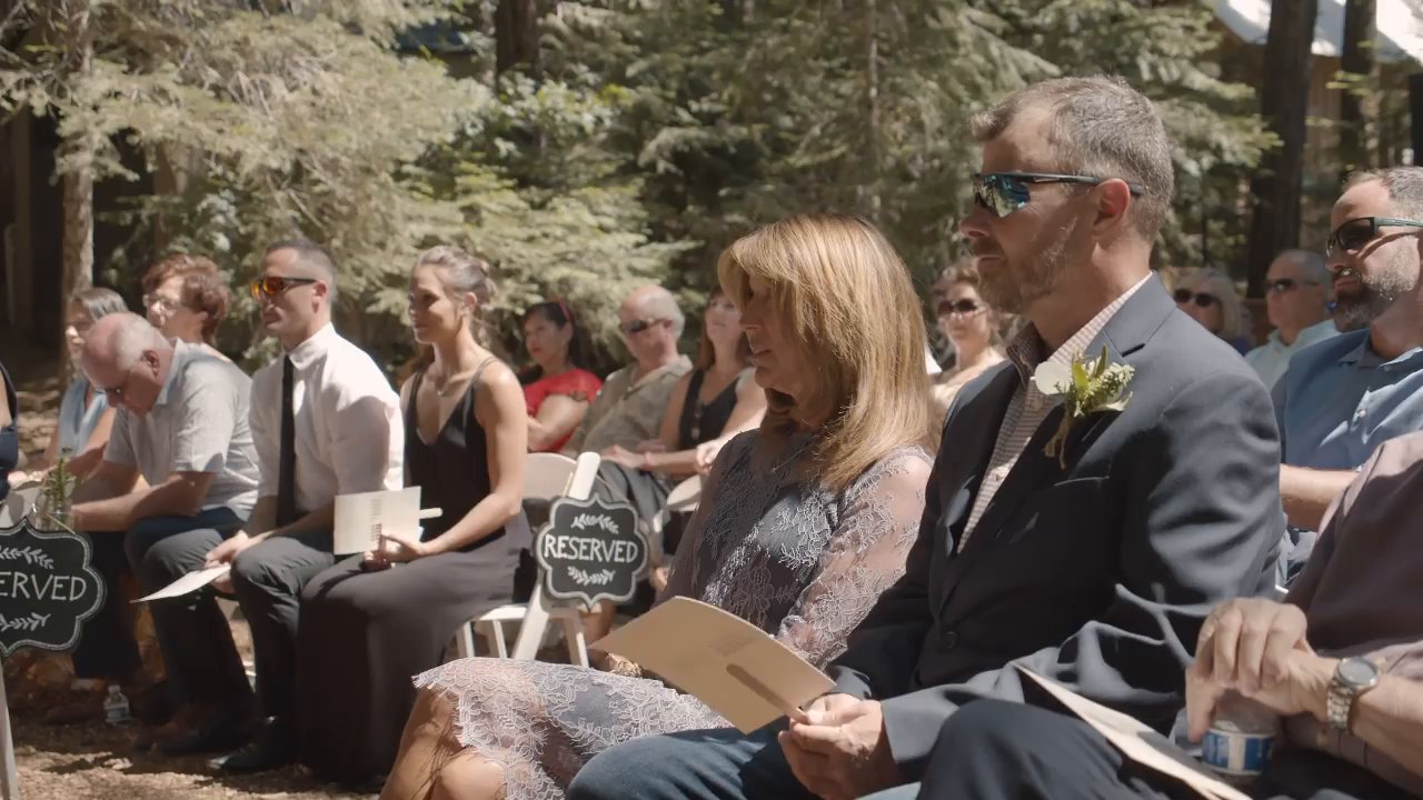 Guests smile from their seats in the forest before the ceremony.