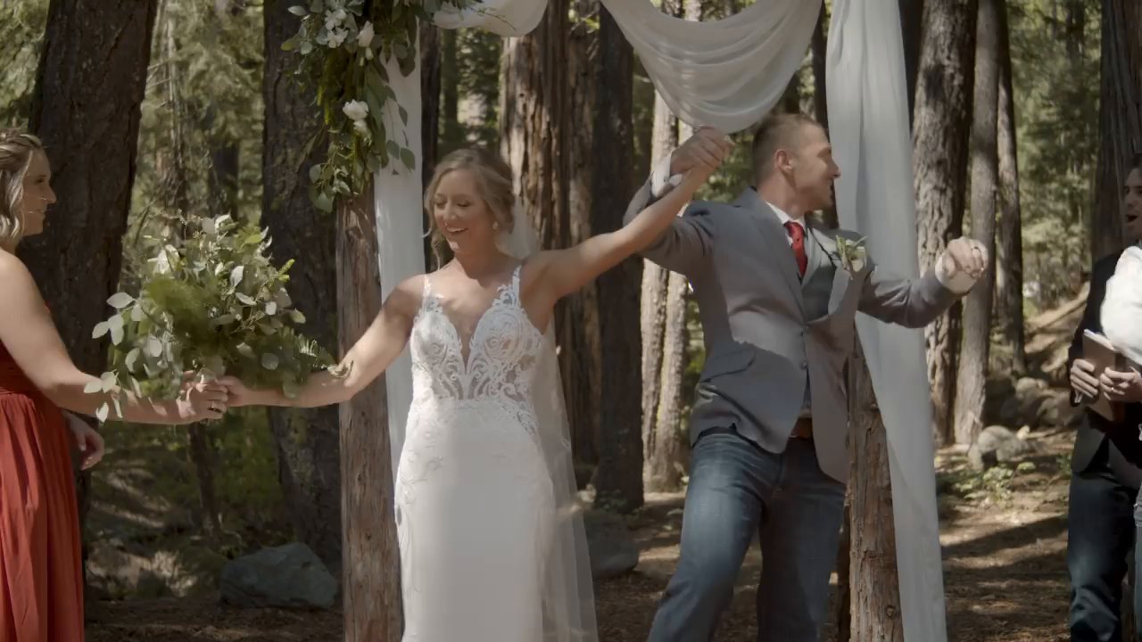 Danielle and Scott raise their arms in a cheer as they start back up the aisle.