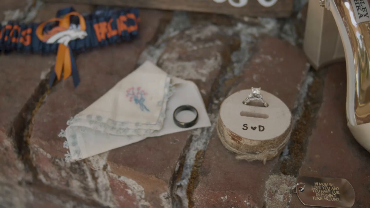 The rings in a wooden S and D box beside an embroidered handkerchief.