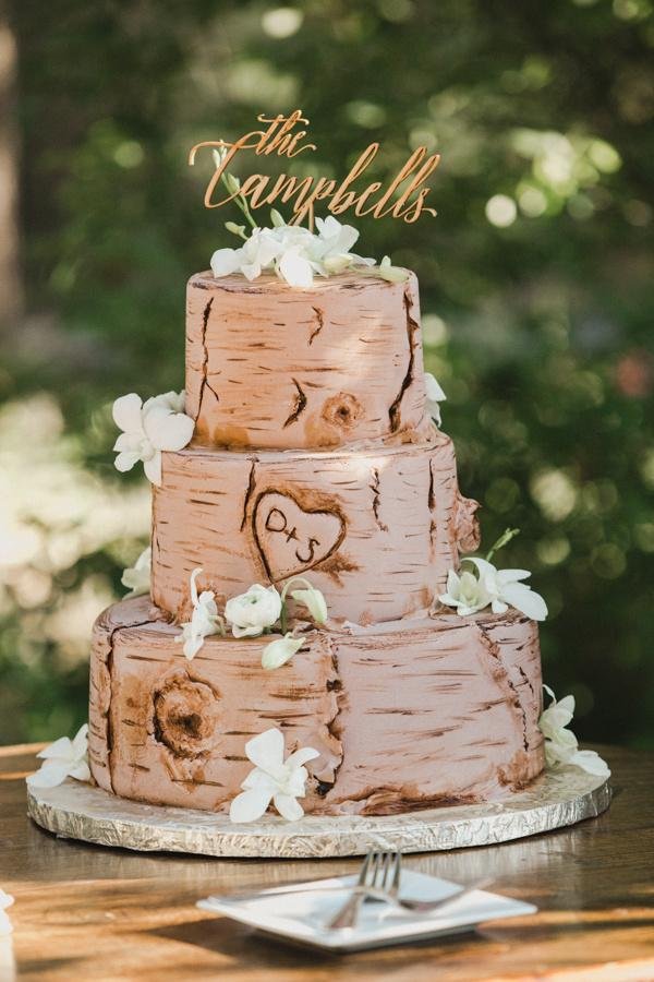 Their birch bark cake with a carved heart under a The Campbells topper, photo by Composing Reality Photography