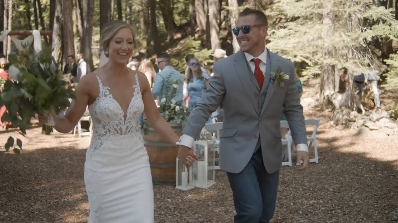 Danielle and Scott walk hand in hand back up the aisle as guests cheer.