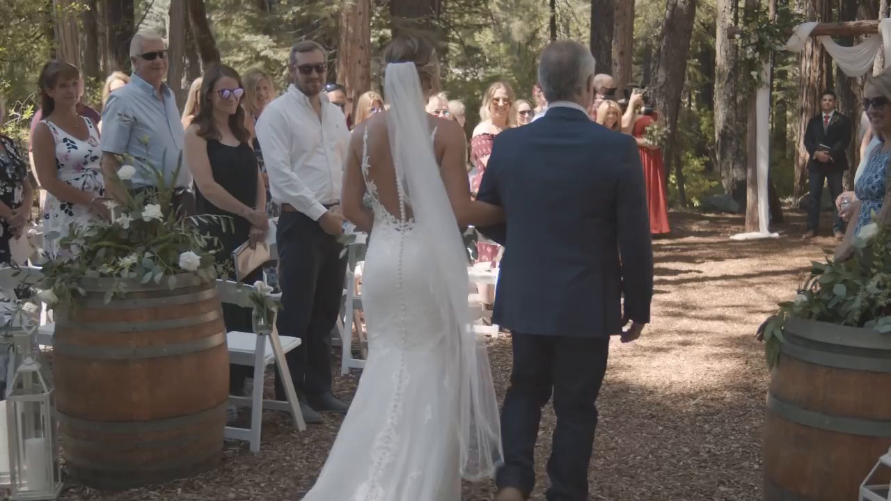 Danielle walks down the forest aisle on her dad's arm.