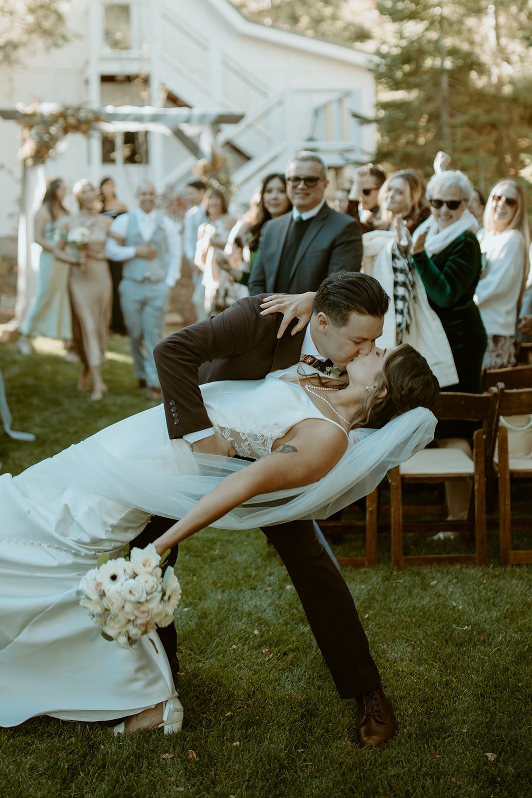 Devin dips Emily for a kiss in the aisle as guests cheer