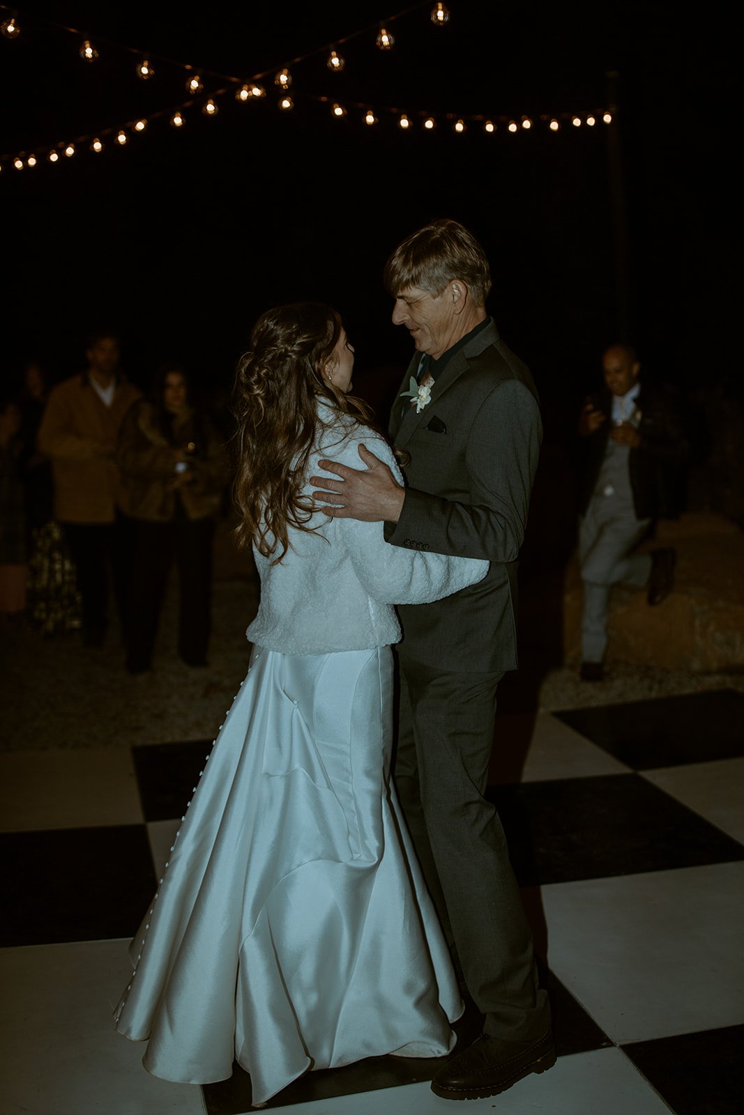 Emily dances with her dad on the checkered floor