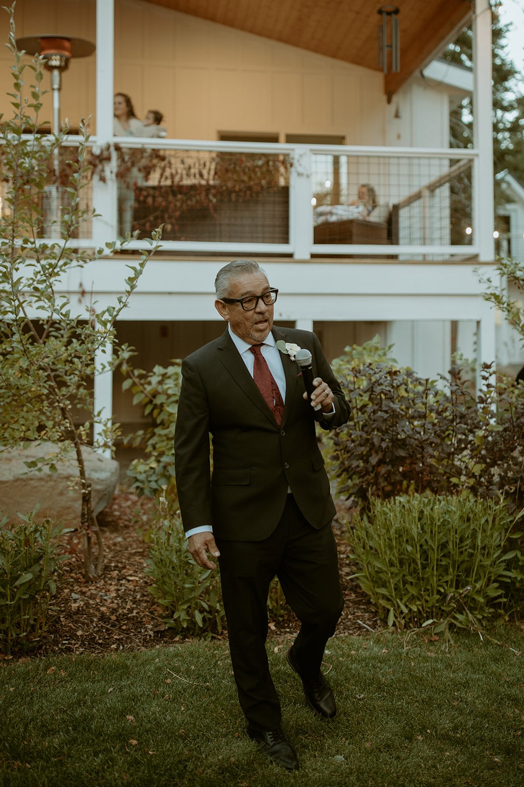 A guest gives a toast on the lawn in front of the house