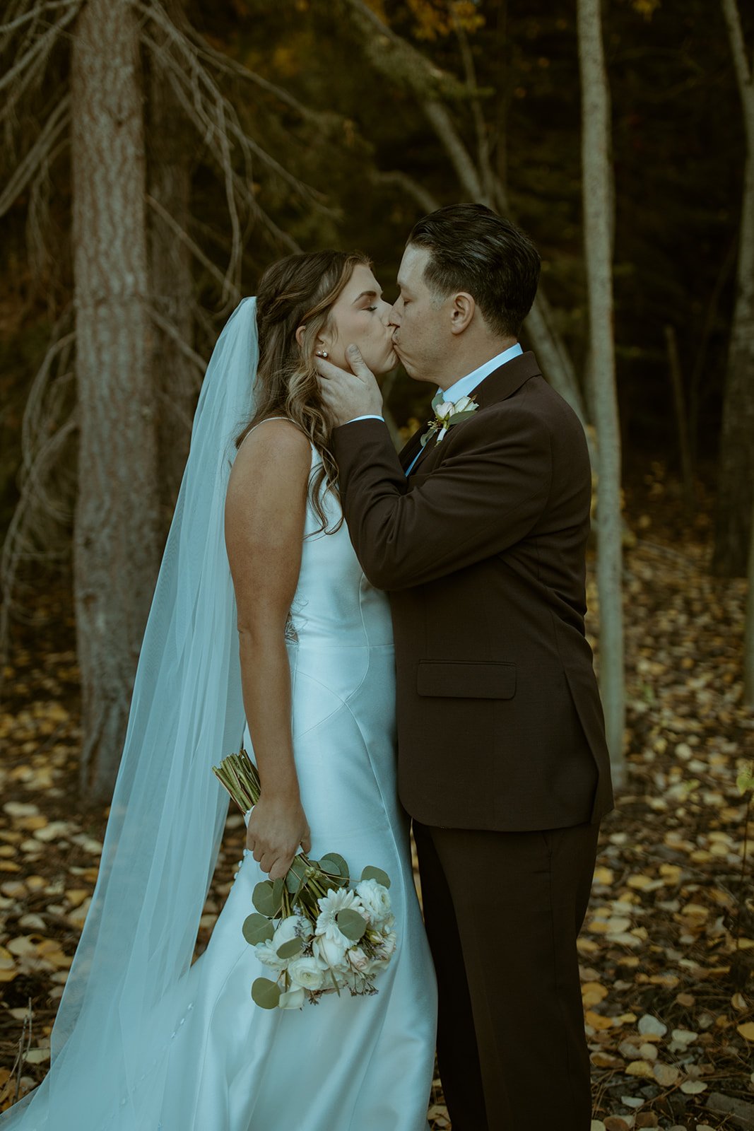 Devin kisses Emily as she holds his face, her veil trailing
