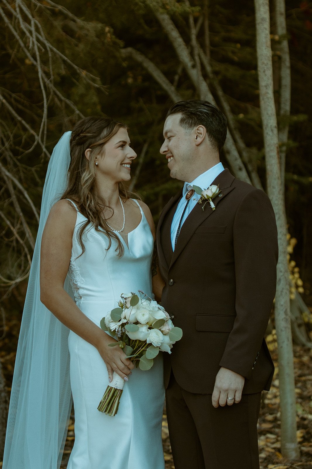 Emily and Devin smile at each other among the aspens