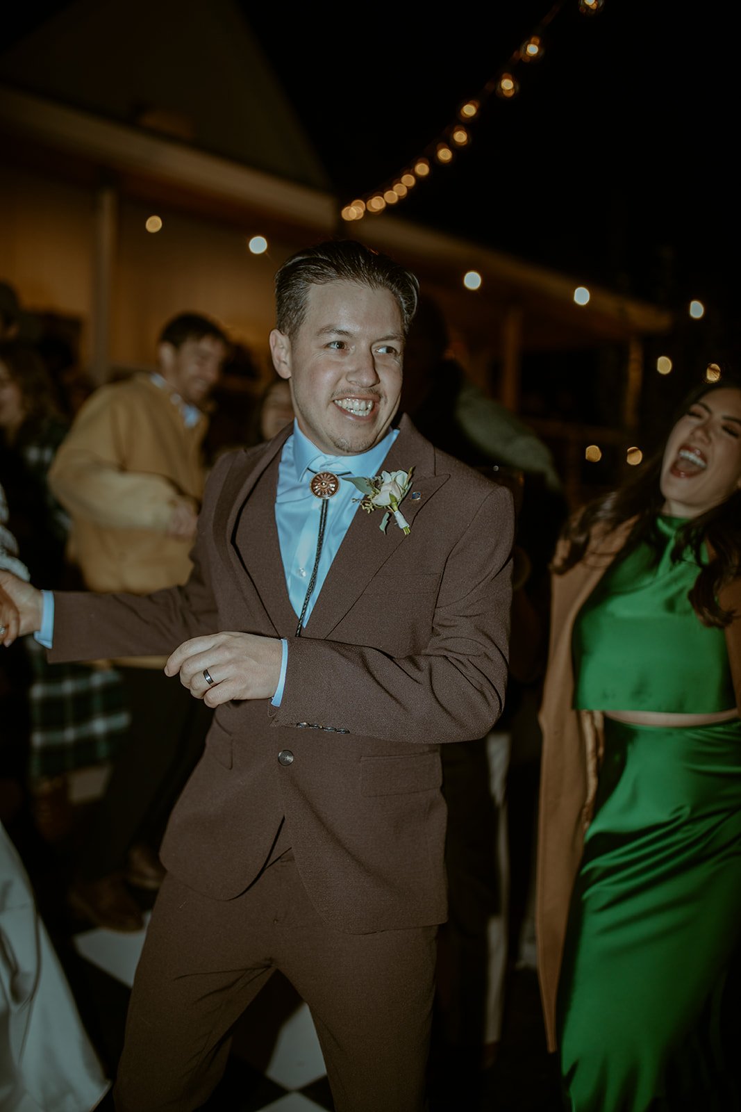 Devin dances with a guest under the string lights