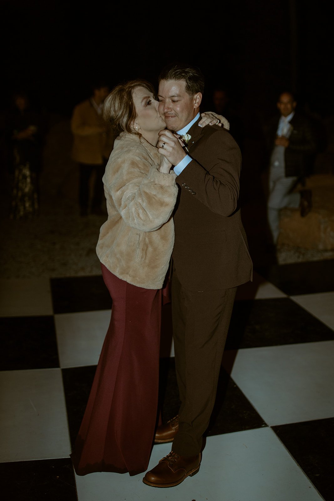 Devin's mom kisses his cheek during their dance