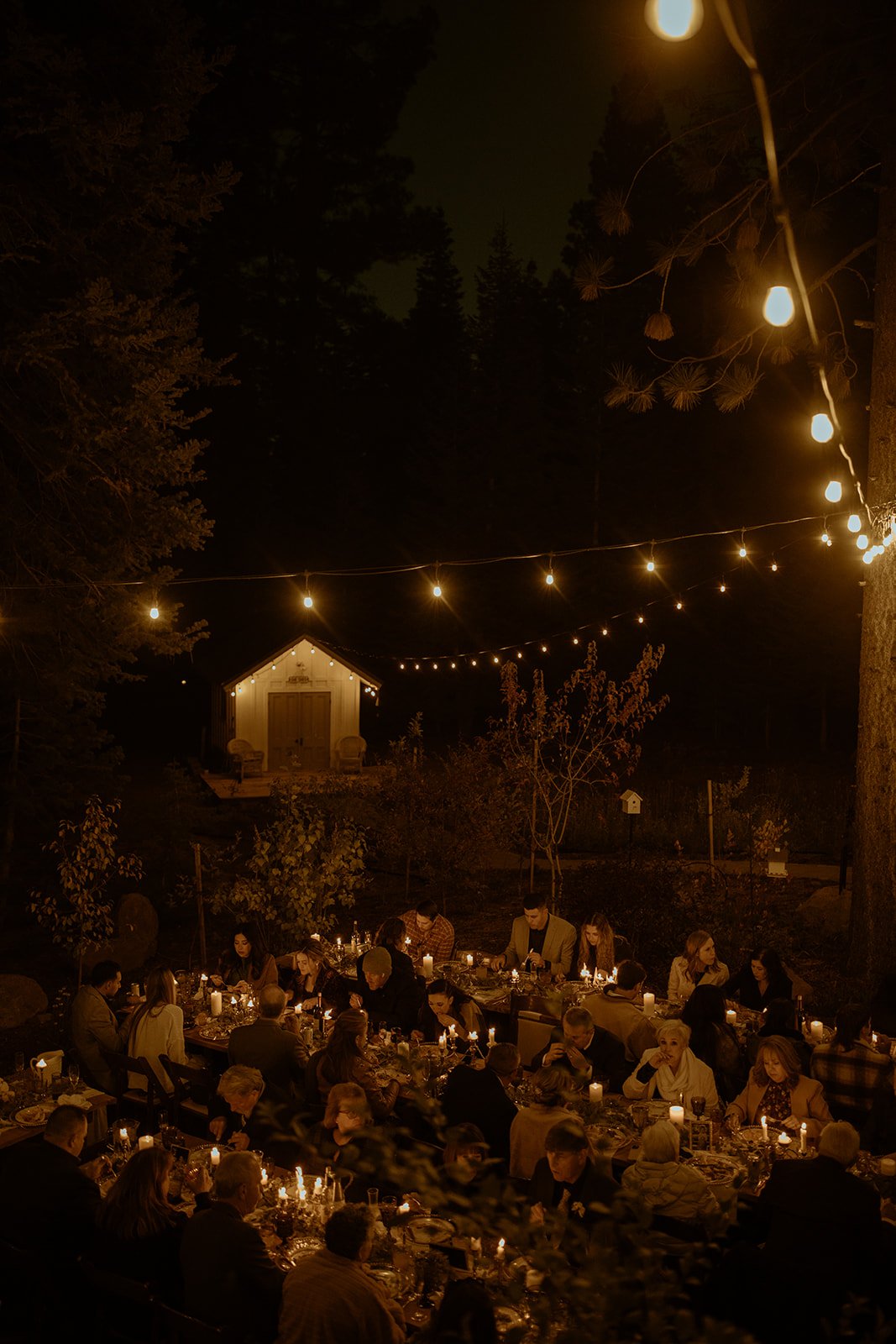 String lights over the candlelit tables at night